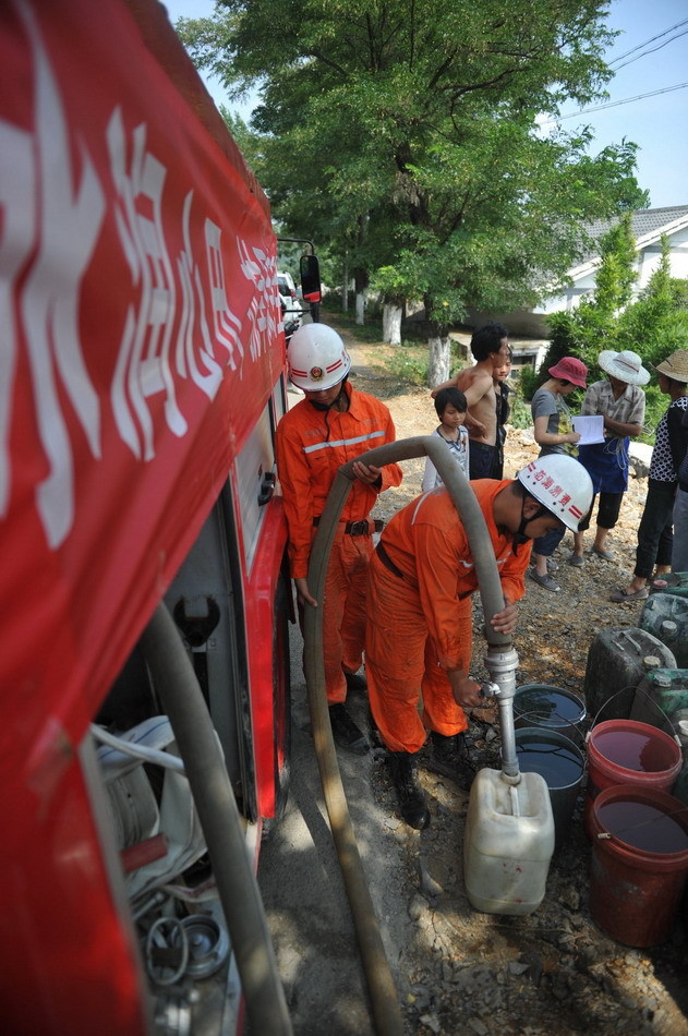 Firefighters transport water in Qianxi County, southwest China&apos;s Guizhou Province, July 28, 2011. Serious drought hit Guizhou in July, affecting more than 29 cities and counties. Local government has been taking measures to fight drought. [Xinuha] 