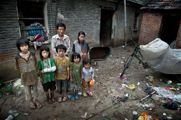 Fifty one year-old Sun Yuanhua and his wife and kids pose for a picture in Woyang county, Bozhou, East China's Anhui province, July 27, 2011.