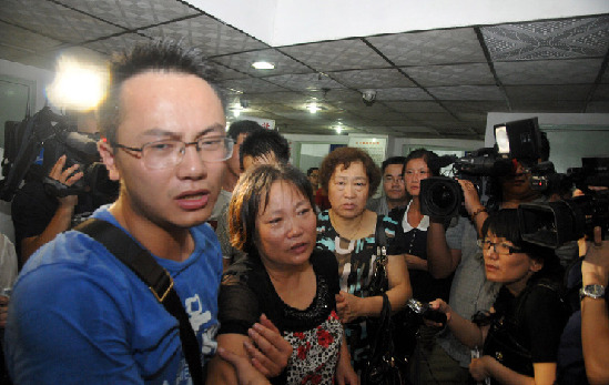 The relatives of a toddler who was rescued about 21 hours after a deadly high-speed train crash are seen in a hospital in East China's Zhejiang Province. The girl was found unconscious around 5:15 pm Sunday when rescuers were clearing a badly damaged carriage. 