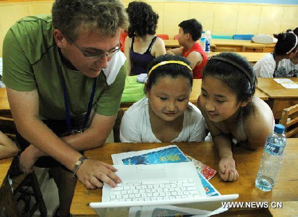 An American exchange student talks with two Chinese students in the Harbin No. 1 Middle School in Harbin, capital of northeast China's Heilongjiang Province, July 28, 2011. Twenty middle school students from the United States began their exchange studies at the school Thursday.