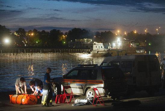 Rescue workers seek for survivors at the site where a pleasure boat carrying 15 people collided with a barge on the Moscow River and sank on July 31, 2011. [Xinhua]