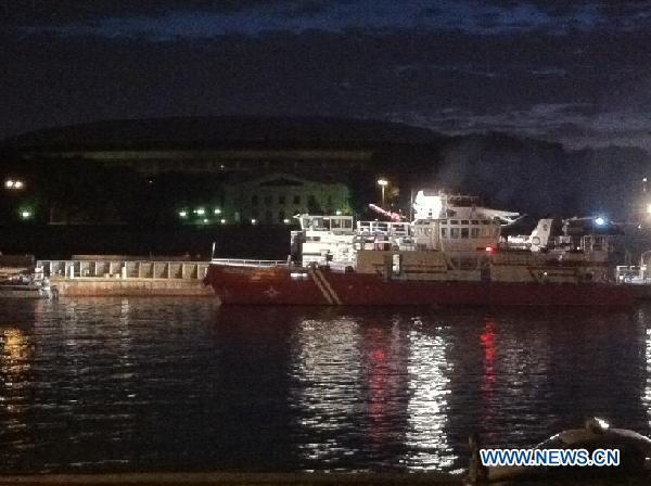 Rescue workers seek for survivors at the site where a pleasure boat carrying 15 people collided with a barge on the Moscow River and sank on July 31, 2011. [Xinhua]