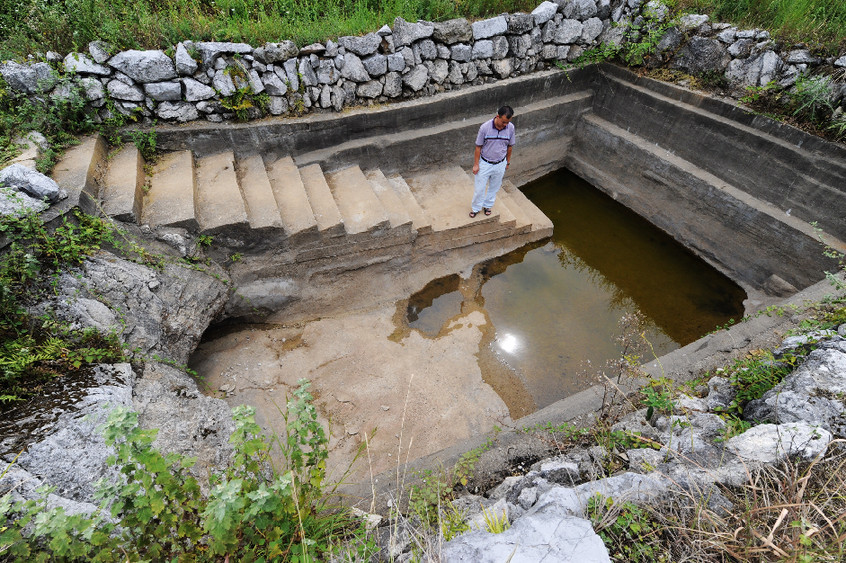 A villager looks at a dried reservoir in Wentang Township, Xinhua County of central China&apos;s Hunan Province, July 30, 2011. Due to high temperature and lack of rainfalls, Hunan has been hit by lasting droughts in recent days. [Xinhua]