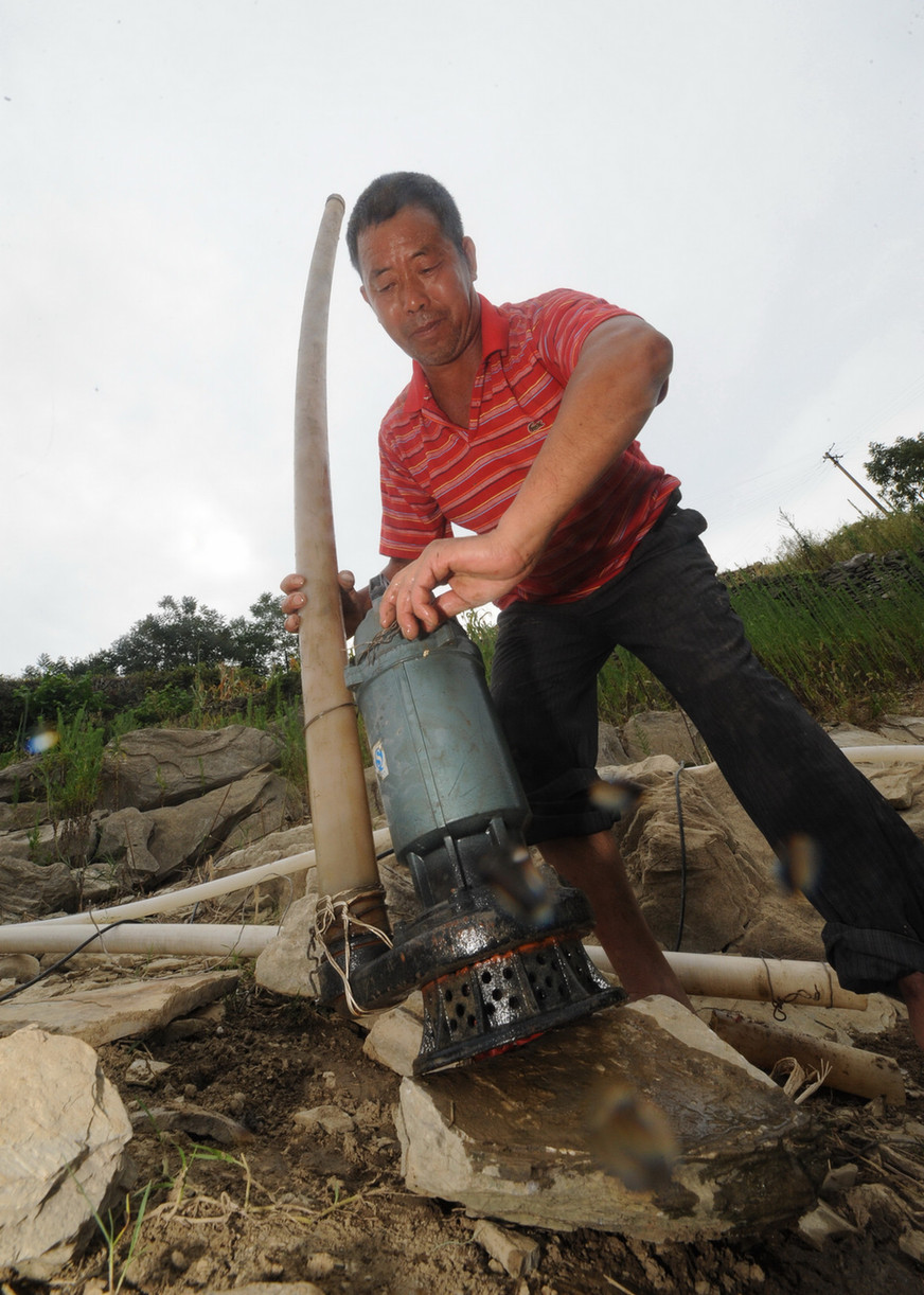 A villager installs water pump for irrigation in Wentang Township, Xinhua County of central China&apos;s Hunan Province, July 30, 2011. Due to high temperature and lack of rainfalls, Hunan has been hit by lasting droughts in recent days. [Xinhua]