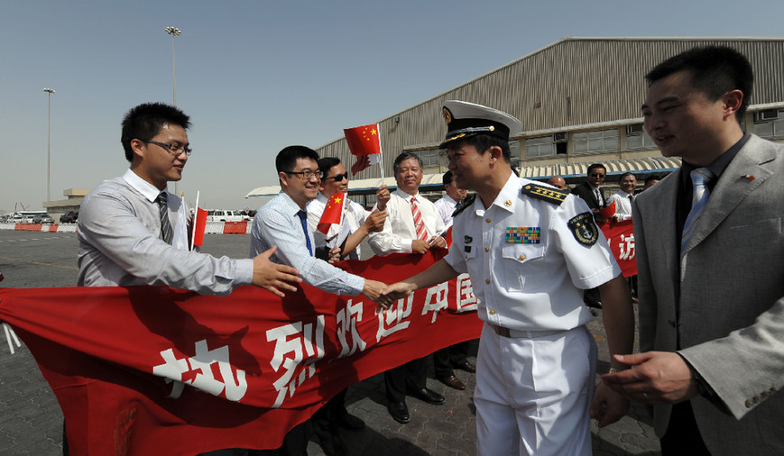 Han Xiaohu, commander of the eighth escort flotilla of Chinese People&apos;s Liberation Army (PLA) Navy in the Gulf of Aden, shakes hands with representitives of overseas Chinese in Qatar during a welcome ceremony in the port of Doha, capital of Qatar, July 30, 2011. Missile frigate Wenzhou, Maanshan and supply ship Qiandaohu arrived in Doha on Sunday, kicking off the first-ever visit by PLA navy to Qatar, which will last for five days. [Xinhua]