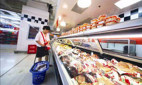 A customer chooses packed meat at a supermarket in Chaoyang district on Sunday.[Global Times]