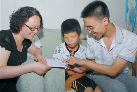 Xu Lina (left) and Duan Fei show 12-year-old Sun Tao how to use simple characters and pictures to communicate. Tao is deaf. Xu and Duan, founders of charity website baoen.cn, took Tao to the hospital in Shijiazhuang, Hebei province, to be evaluated for a hearing aid.