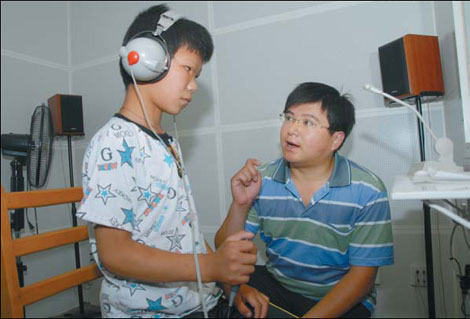 Sun Tao undergoes one of many hearing tests. Teacher Wang Hui, from Gucheng Special Education School in Hebei, accompanied his orphaned pupil through the long day.