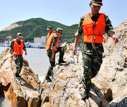 Frontier policemen patrol high-risk areas in coastal Wenling, Zhejiang Province, yesterday as super typhoon Muifa headed toward the eastern China province. [Shanghai Daily]