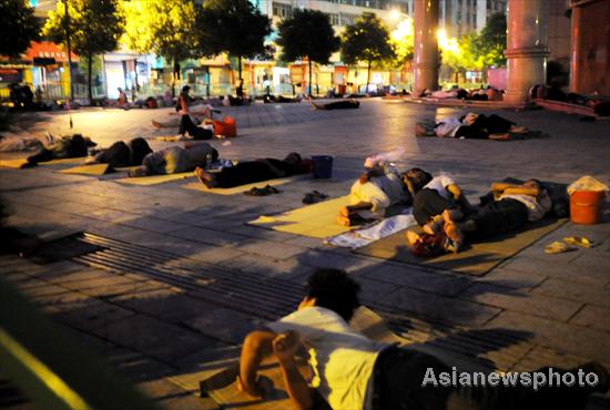 Jobless migrant workers sleep on the street near a job market in Yiwu city, East China's Zhejiang province, on August 4, 2011. [Photo/Asianewsphoto]