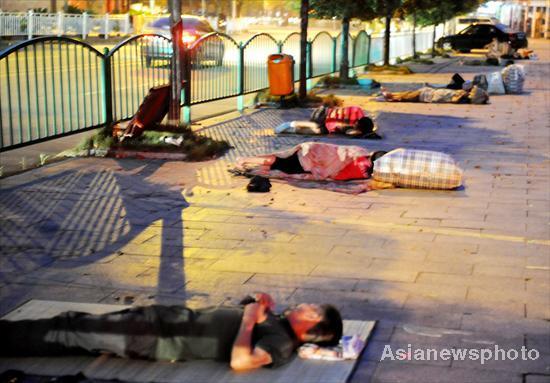 Jobless migrant workers sleep on the street near a job market in Yiwu city, East China's Zhejiang province, on August 4, 2011. [Photo/Asianewsphoto] 