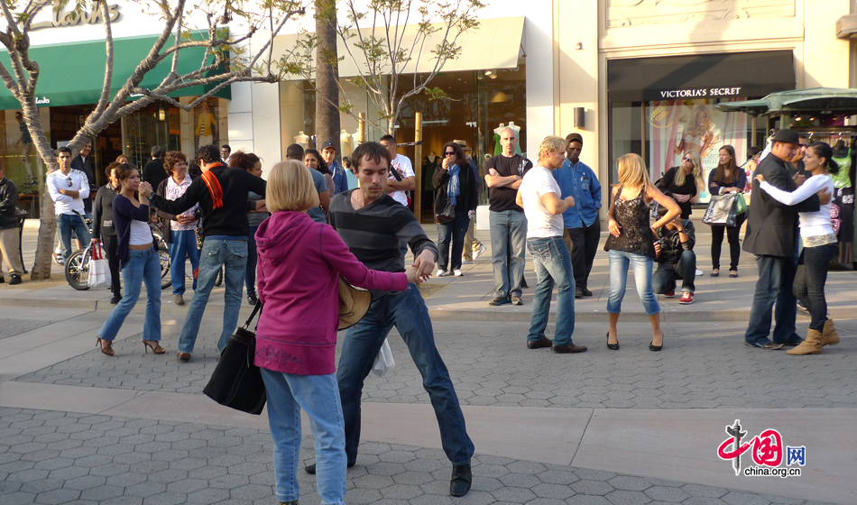 People are dancing on the Third Street Promenade, a major outdoor pedestrian-only shopping district that stretches for three blocks, where allows people to stroll, congregate, shop and enjoy street performers. [Photo by Xu Lin / China.org.cn]