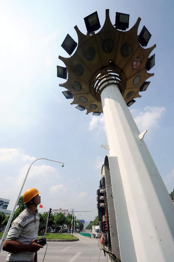 A power supply worker lowers the high mast street lamps in Taizhou, east China&apos;s Zhejiang Province, Aug. 4, 2011. Typhoon Muifa will very likely make landfall in the eastern part of the province Saturday night and cause significant damage. Warnings have also been issued to fishing boats in the area.