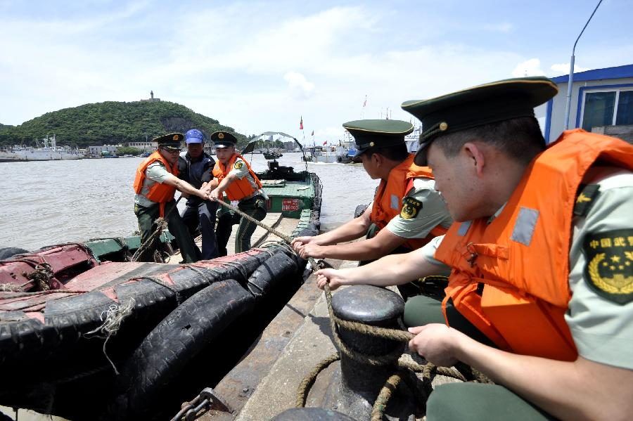 Soldiers help fishermen to reinforce their fishing vessels in Shenjiamen fishing port of Zhoushan, east China&apos;s Zhejiang Province, Aug. 4, 2011. Typhoon Muifa will very likely make landfall in the eastern part of the province Saturday night and cause significant damage. Warnings have also been issued to fishing boats in the area. [Xinhua]