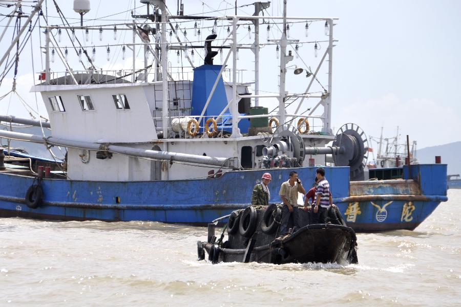 Fishermen on a barge go ashore to shelter from typhoon in Shenjiamen fishing port of Zhoushan, east China&apos;s Zhejiang Province, Aug. 4, 2011. Typhoon Muifa will very likely make landfall in the eastern part of the province Saturday night and cause significant damage. Warnings have also been issued to fishing boats in the area. [Xinhua] 