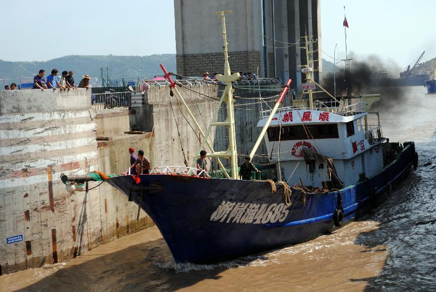 A fishing boat sails to the harbor to shelter from Typhoon Muifa in Taizhou, east China&apos;s Zhejiang Province, Aug. 4, 2011. Typhoon Muifa will very likely make landfall in the eastern part of the province Saturday night and cause significant damage. Warnings have also been issued to fishing boats in the area. [Xinhua]