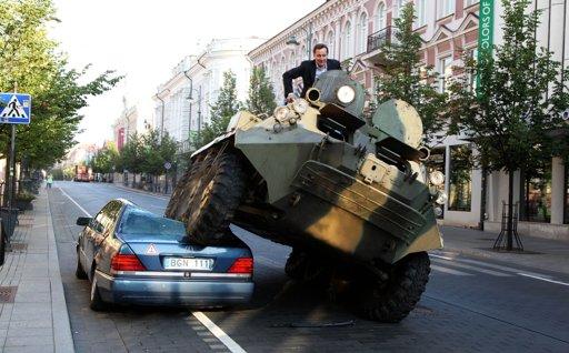In this Tuesday, August 2, 2011 photo distributed by Vilnius City Municipality press service, Arturas Zuokas, the 43 year old mayor of Vilnius drives over a car parked illegally on a main street in Vilnius city center with a military vehicle. 
