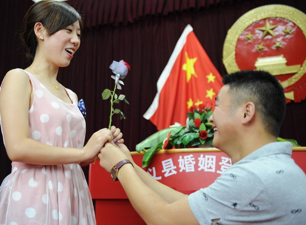 A man proposes to his girlfriend in a marriage registry office in Wuyi county, Zhejiang province, Aug 6, 2011. [Photo/Xinhua]