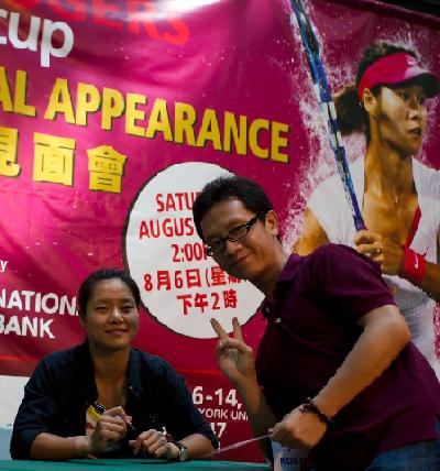 China's Li Na (L) poses with a fan as she goes to the Pacific Mall to interact with fans in Toronto, Canada, Aug. 6, 2011. No. 6 seeded player Li Na will compete in the 2nd round of the 2011 Rogers Cup. 