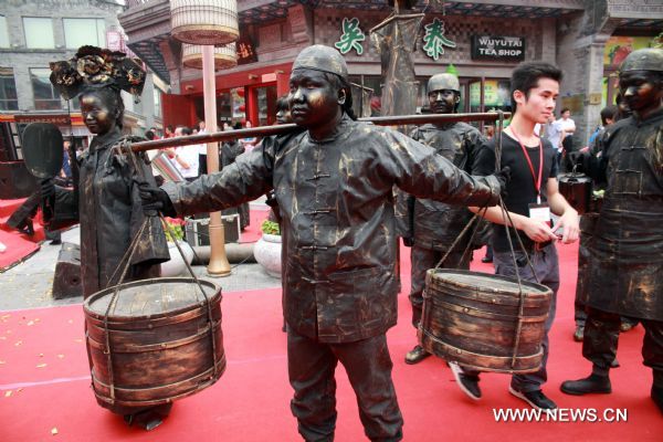 Performers, dressed up as people in the Qing Dynasty (1644-1911), present a body sculpture show during the Second Qianmen Historic and Cultural Festival on Qianmen Street in Beijing, capital of China, Aug. 7, 2011. The 10-day festival kicked off here on Sunday. (Xinhua/Chen Xiaogen) (zl) 