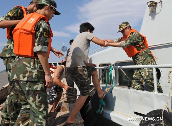 A trapped crew member is transfered to a fishery administration ship in Damaiyu sea area in Taizhou, east China's Zhejiang Province, Aug. 7, 2011. A fishing vessel with about 50 meters in length took the ground around 1:30 a.m. Sunday. All the nine crew members have been rescued. 