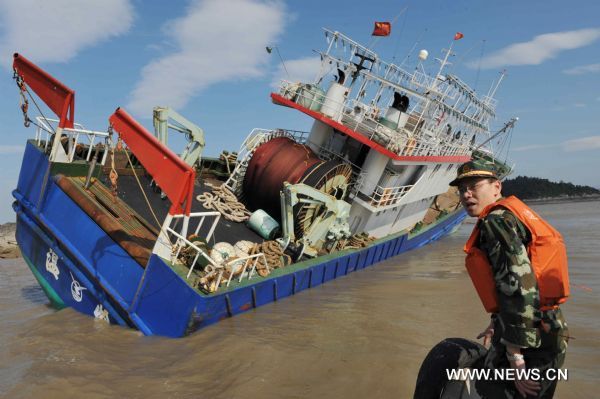 A rescuer works to rescue a stranded ship in Damaiyu sea area in Taizhou, east China's Zhejiang Province, Aug. 7, 2011. A fishing vessel with about 50 meters in length took the ground around 1:30 a.m. Sunday. All the nine crew members have been rescued.