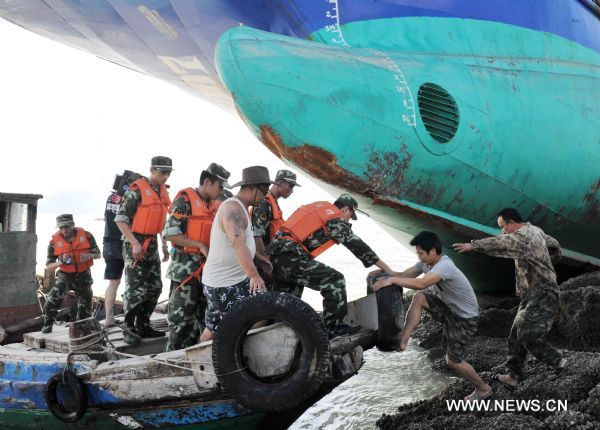 A trapped crew member (2nd R) is rescued in Damaiyu sea area in Taizhou, east China's Zhejiang Province, Aug. 7, 2011. A fishing vessel with about 50 meters in length took the ground around 1:30 a.m. Sunday. All the nine crew members have been rescued. 