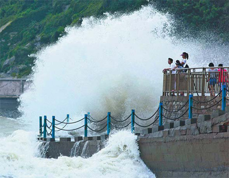 A huge wave strikes at a port in Lianyungang, Jiangsu province, on Sunday. Typhoon Muifa, the ninth typhoon to hit China this year, is weakening as it moves north along the country's affluent and densely populated eastern coastline. [China Daily]