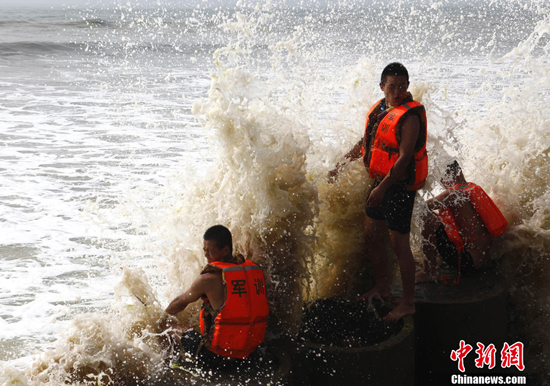 A huge wave strikes at a port in Shandong Province, on Sunday. Typhoon Muifa, the ninth typhoon to hit China this year, is weakening as it moves north along the country's affluent and densely populated eastern coastline. 