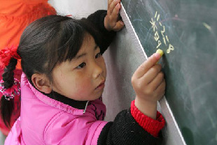 A girl from a rural area of Guizhou Province does sums on the blackboard. [File photo from China Education Press Agency] 