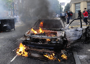 A car lit by rioters is seen on a street in Hackney, east London, Britain, Aug. 8, 2011. Rioting starting late Saturday appeared spreading across London on Monday, with vandalising, arson and looting taking place in various London communities. [Zeng Yi/Xinhua] 