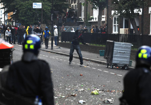 A rioter throws missiles to policemen on a street in Hackney, east London, Britain, Aug. 8, 2011. Rioting starting late Saturday appeared spreading across London on Monday, with vandalising, arson and looting taking place in various London communities. [Zeng Yi/Xinhua] 