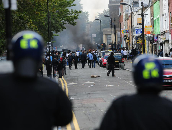 Policemen stand guard on a street in Hackney, east London, Britain, Aug. 8, 2011. Rioting starting late Saturday appears spreading across London on Monday, with vandalising, arson and looting taking place in various London communities. [Zeng Yi/Xinhua] 