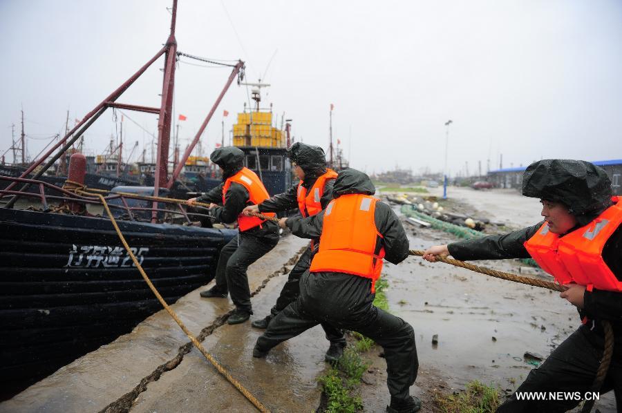 Chinese marine policemen try to port a vessel in Dandong, a coastal city in northeast China's Liaoning Province, Aug. 8, 2011. Typhoon Muifa was predicted to make landfall in coastal areas of Dandong on Monday night. [Xinhua]