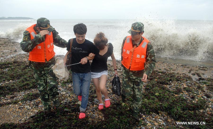 Soldiers of Chinese border guard help tourists evacuate from a seashore in Dalian, a coastal city in northeast China's Liaoning Province, as the Typhoon Muifa approaches the coast of the province on Aug. 8, 2011. [Xinhua]