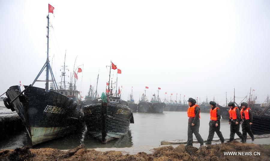 Chinese marine policemen patrol on the seashore in Dandong, a coastal city in northeast China's Liaoning Province, Aug. 8, 2011. Typhoon Muifa was predicted to make landfall in coastal areas of Dandong on Monday night. [Xinhua]