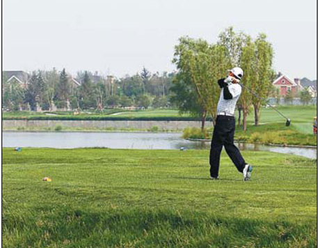 A golfer tees off at a golf course in Beijing in June. There are concerns that keeping the city's luxury-sport facilities prisine is depleting the water resources used by residents. [China Daily] 