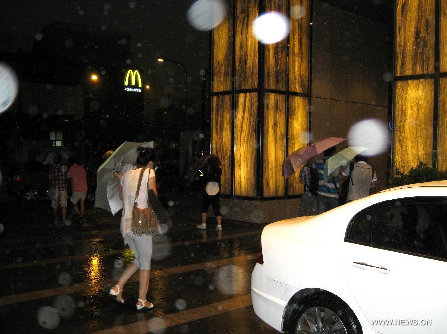 People walk against rain in Beijing, capital of China, Aug. 9, 2011. Beijing was hit by a heavy rainfall on Tuesday. [Xinhua]