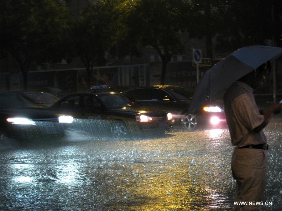 Cars run in the rain in Beijing, capital of China, Aug. 9, 2011. Beijing was hit by a heavy rainfall Tuesday. [Xinhua]