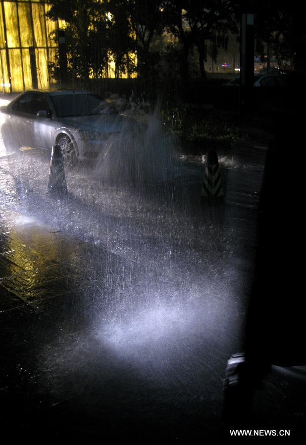 A car runs on a road flooded by a heavy rainfall in Beijing, capital of China, Aug. 9, 2011. Beijing was hit by a heavy rainfall Tuesday. [Xinhua]