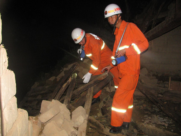 Rescue workers inspect a collapsed house after a 5.2-magnitude earthquake hit Baoshan city in Southwest China's Yunnan province August 9, 2011. Two people were injured, said local authorities. [Photo/Xinhua]