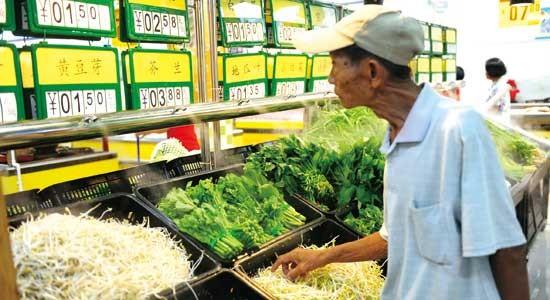 A customer checks the price of vegetables at a supermarket in Qionghai, Hainan Province Tuesday. China's consumer prices in July reached 6.5 percent, the highest level in three years.