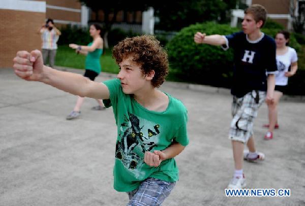 German students practice Chinese Kung Fu in the NO. 168 High School in Hefei, central China's Anhui Province, Aug. 9, 2011. 