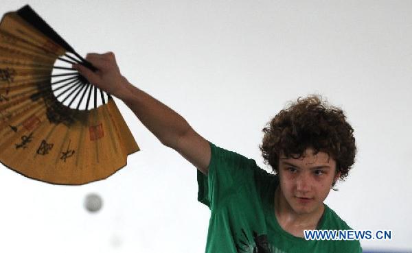 German student Jannick learns to play pingpong with a Chinese fan in the NO. 168 High School in Hefei, central China's Anhui Province, Aug. 9, 2011.