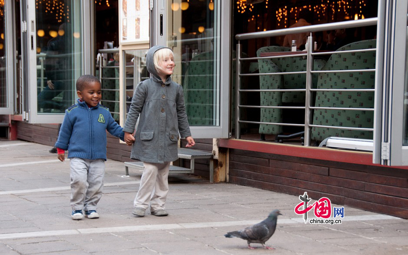 A mixed-race couple of children walk in Nelson Mandela Square in Johannesburg, South Africa, seemingly indifferent to the implications that their skin color may have had under apartheid 17 years ago. [Maverick Chen / China.org.cn]