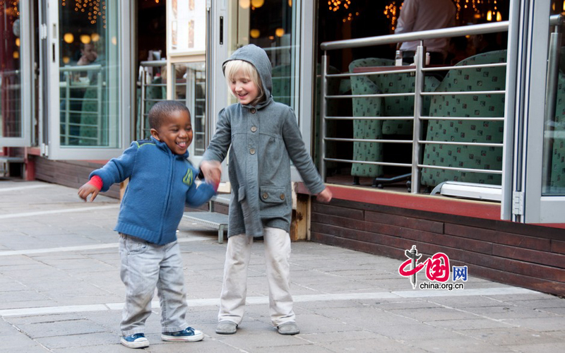 A mixed-race couple of children walk in Nelson Mandela Square in Johannesburg, South Africa, seemingly indifferent to the implications that their skin color may have had under apartheid 17 years ago. [Maverick Chen / China.org.cn]