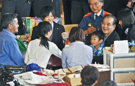 Premier Wen Jiabao (second right) meets tsunami survivors during his visit to the makeshift shelter at Tatekoshi Elementary School in Natori, Miyagi prefecture, on May 21. Wen arrived in northeastern Japan and mourned victims of the country's massive earthquake and tsunami, ahead of the three-way summit among Japan, China and the Republic of Korea. [Kazuhiro Nogi/Agence France-Presse]