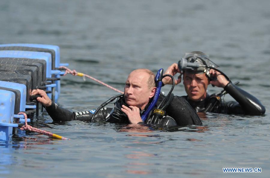 Russian Prime Minister Vladimir Putin (C) prepares to dive at an archaeological site off the Taman peninsular in southern Russia August 10, 2011. (Xinhua/Reuters Photo)