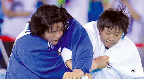 China's Qin Qian (R) grapples with Kim Na-young of South Korea in the women's judo over-78kg event in Shenzhen, Aug 13, 2011. Qin beat Kim to win China's first Shenzhen Universiade gold. 