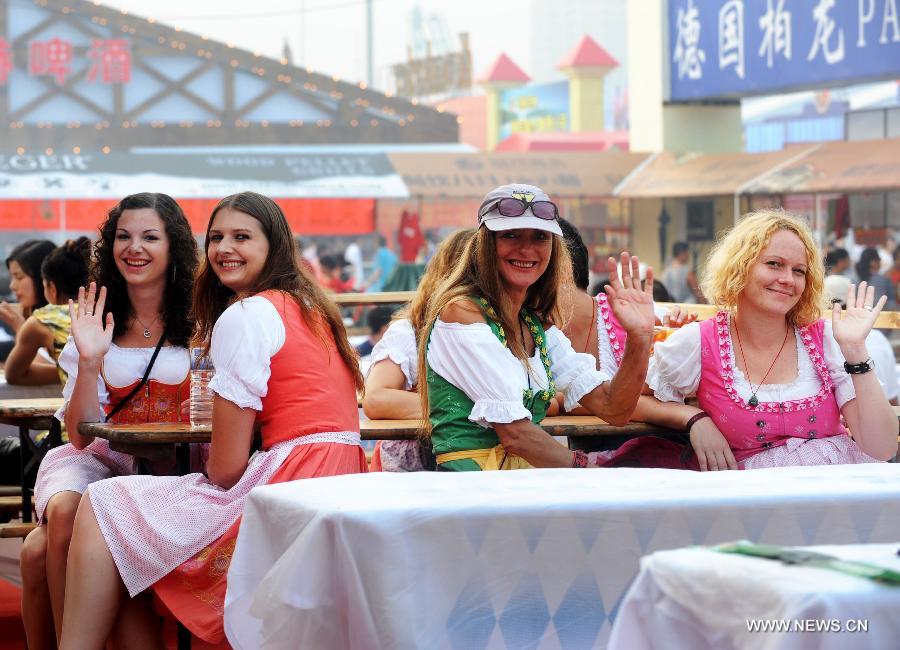 German tourists enjoy themselves at the 21st International Beer Festival at the beer city in Qingdao, east China's Shandong Province, Aug. 14, 2011. Qingdao's 21st International Beer Festival, a 16-day event, opened on Saturday, in which over 200 kinds of beer products of 20 well known brands are presented for beer lovers. A total of 77 tons of beer were sold during its first day. [Xinhua/Li Ziheng]